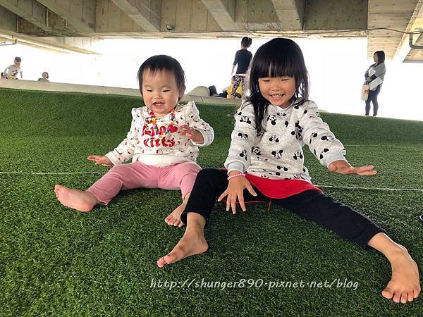 兩位小女孩在草皮上玩耍