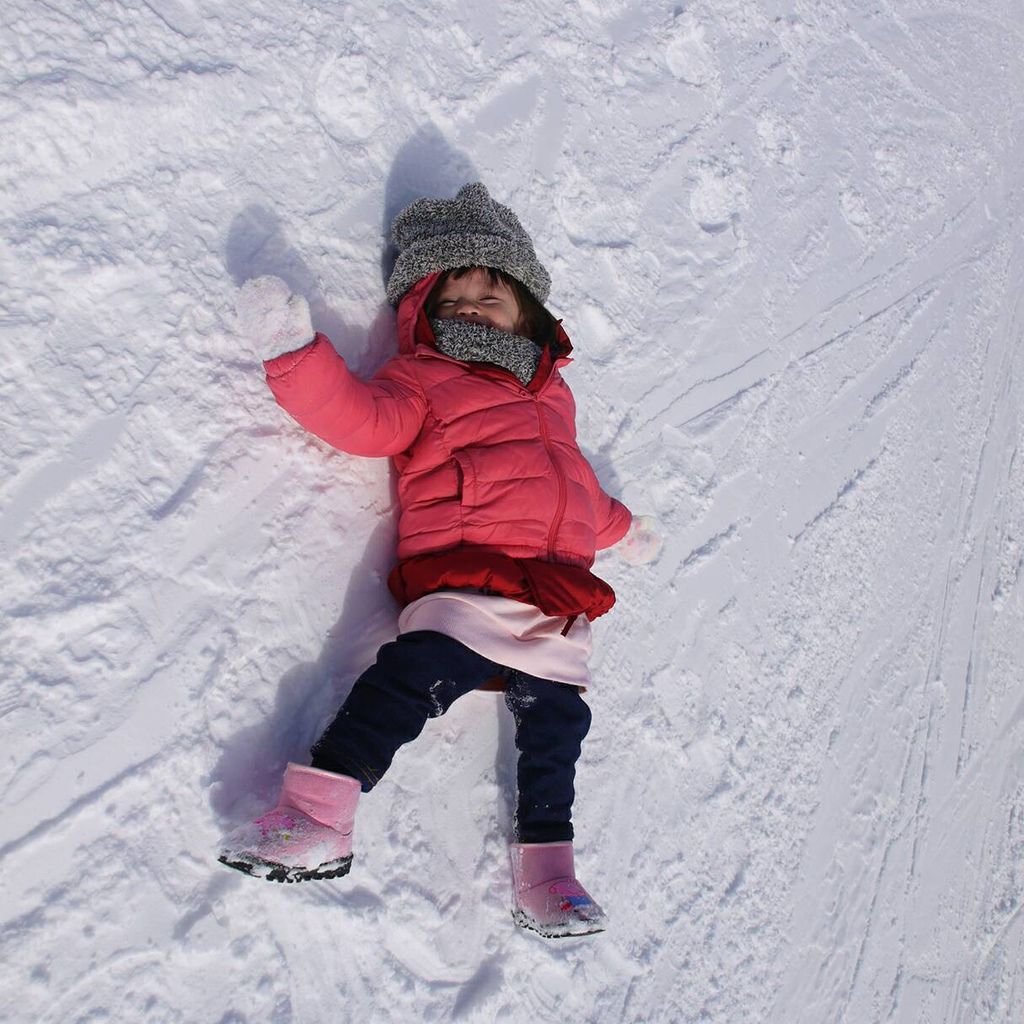 小女孩躺在雪地裏