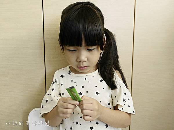 小女孩看著蘋果口味的敏立清益生菌